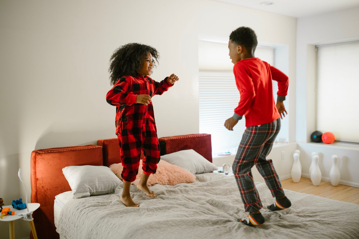 two young children bouncing on spring mattress