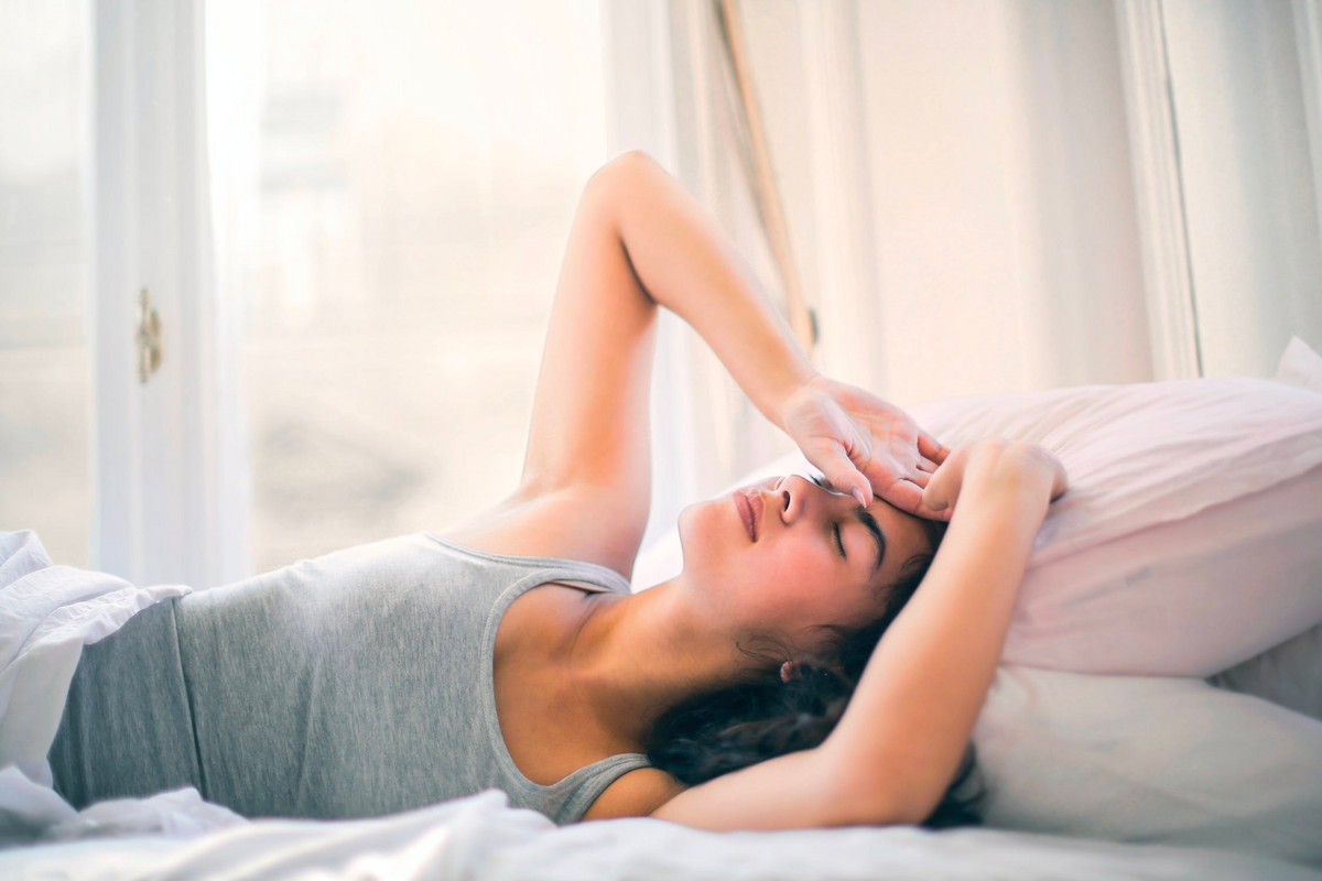 women laying with eyes closed on pink pillow